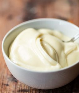 mayonnaise in small white bowl with teaspoon in