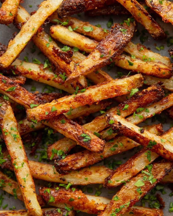 overhead shot of fries fresh out the oven garnished with parsley