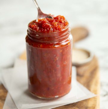 chutney in a clear jar with teaspoon popping out the top