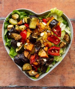 overhead shot of salad in heart shape salad bowl