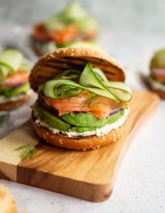bagel sandwich on chopping board with 3 others blurred in background