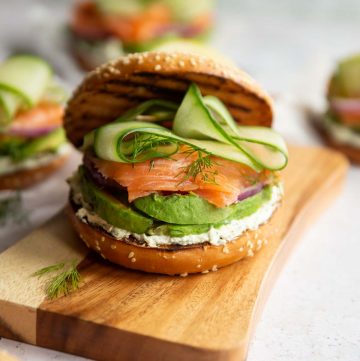 bagel sandwich on chopping board with 3 others blurred in background