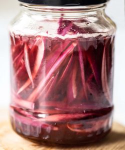 close up shot of pickled onions in glass jar