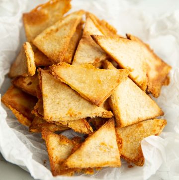 grilled cheese chips in crumpled parchment paper on marble backdrop