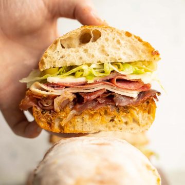 close up shot of hand holding sandwich showing filling