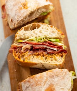 close up shot of sliced ciabatta sandwich on chopping board