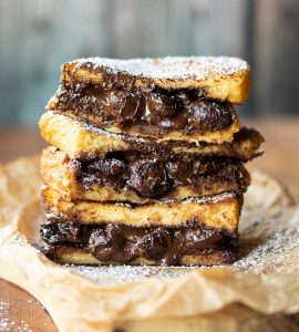3 French toast sandwiches stacked on each other with chocolate spilling out