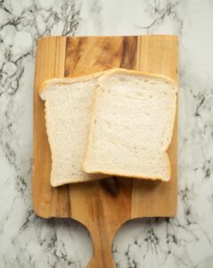 overhead shot of two slices of bread on wooden chopping board